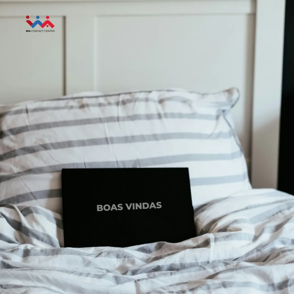 Uma placa em cima da cama de um hotel com a saudação de Boas-vindas